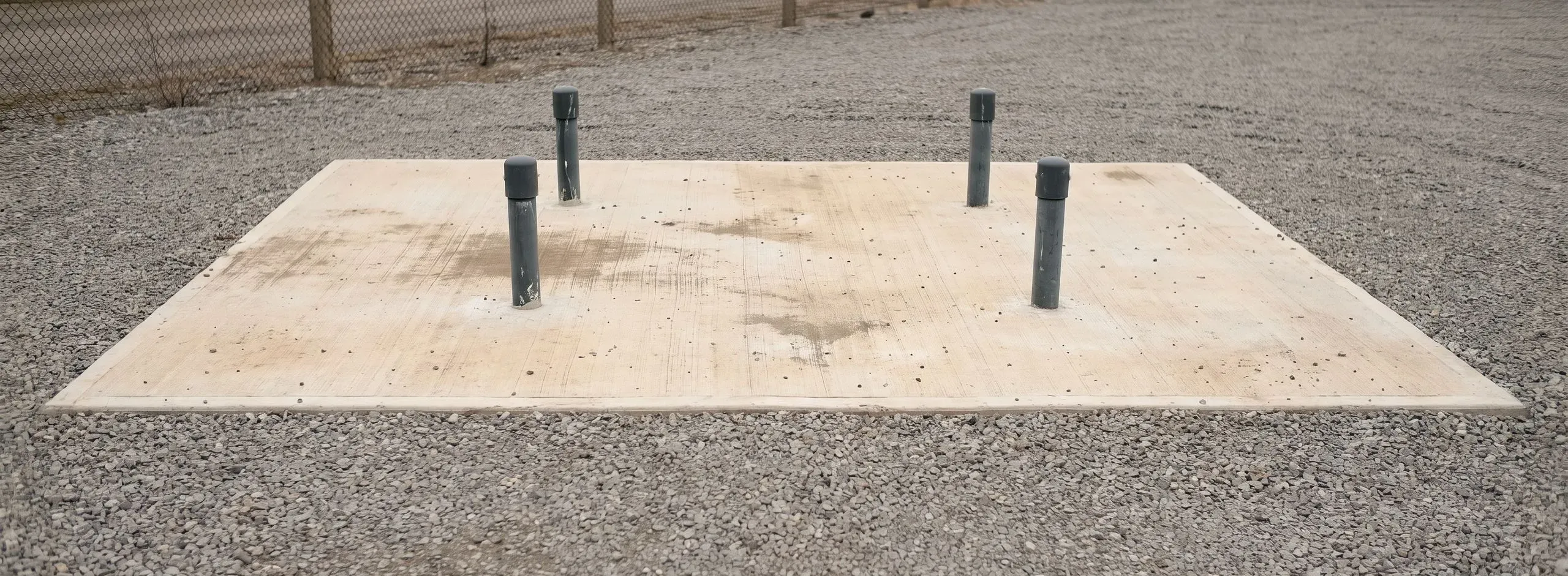 Vorbereitetes Betonfundament auf Schotter mit abgedeckten Kabelschutzrohren