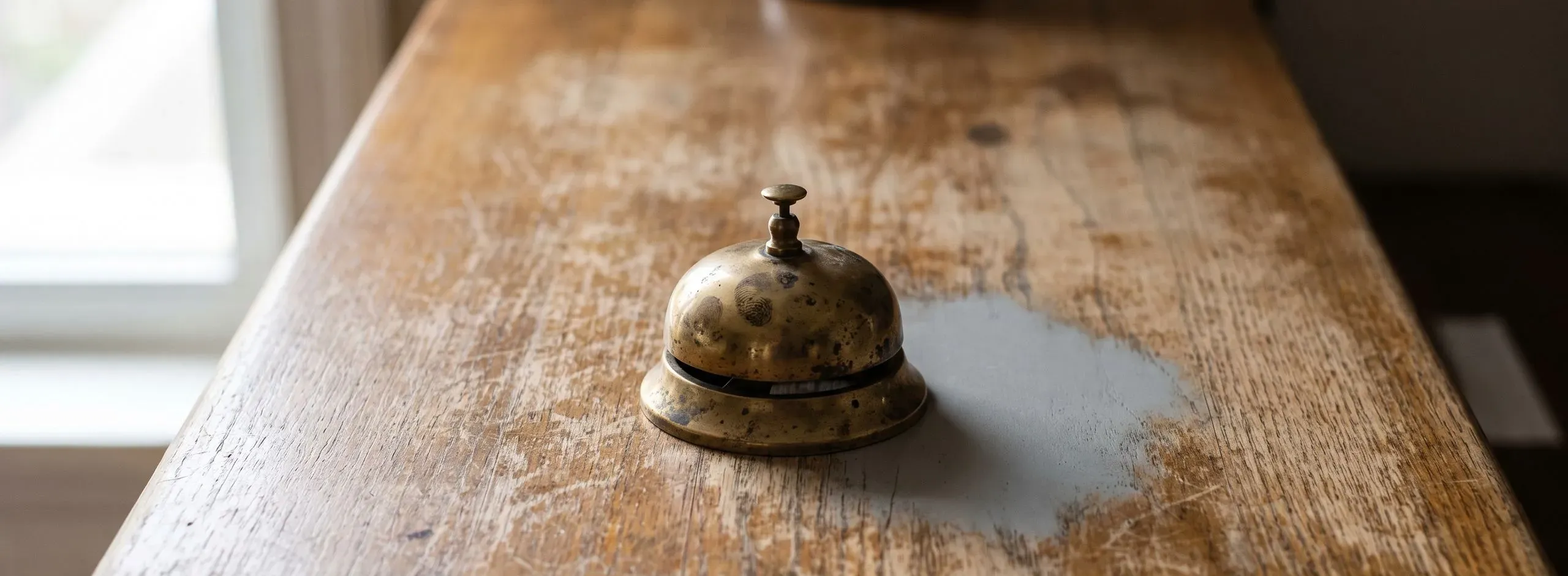 Messingglocke auf einem abgenutzten Holztresen